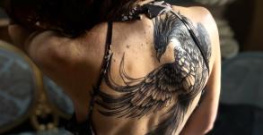 Tatouage phénix noir et gris dans le dos féminin réalisé par Tamara Chaudesaigues chez Graphicaderme à Chaudes-Aigues