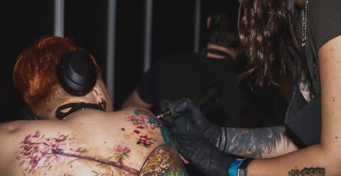 Tamara Chaudesaigues en séance de tatouage à Avignon, travaillant un tatouage de dos en couleur au studio Graphicaderme