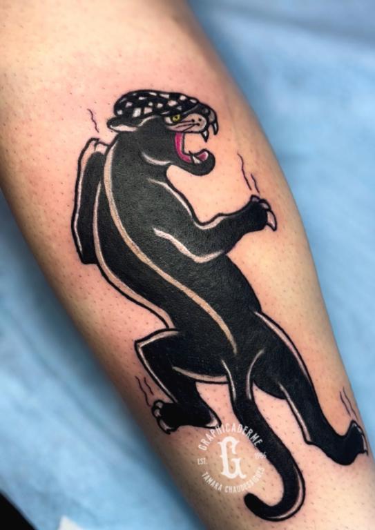 Tatouage panthère old school avec casquette, inspiré du style Peaky Blinders, réalisé par Tamara Chaudesaigues chez Graphicaderme, studio de tatouage à Avignon