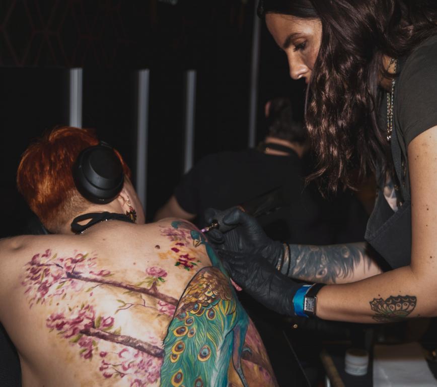 Tamara Chaudesaigues en séance de tatouage à Avignon, travaillant un tatouage de dos en couleur au studio Graphicaderme